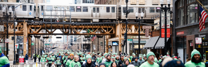 Participants running under El track during the 2025 Bank of America Shamrock Shuffle